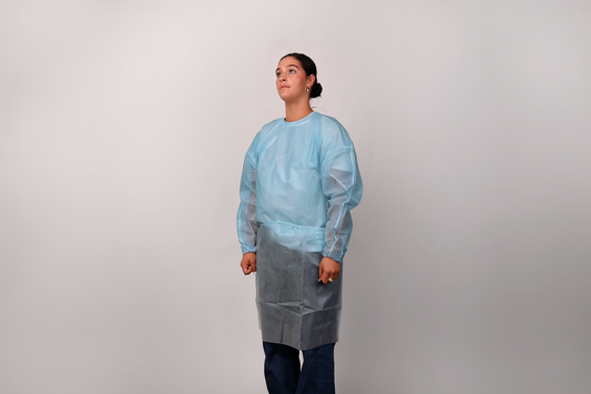 Person wearing a blue isolation gown on a grey background