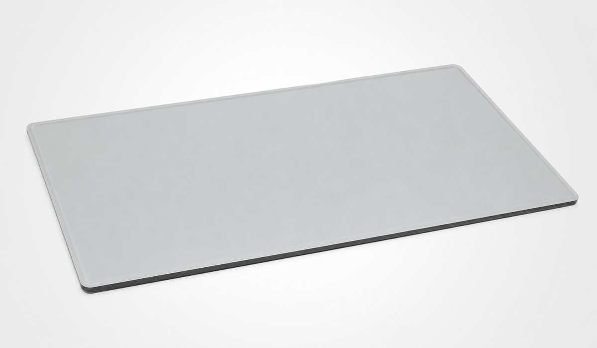 A minimalist, rectangular light gray desk mat with rounded corners, shown at an angle on a clean white background.