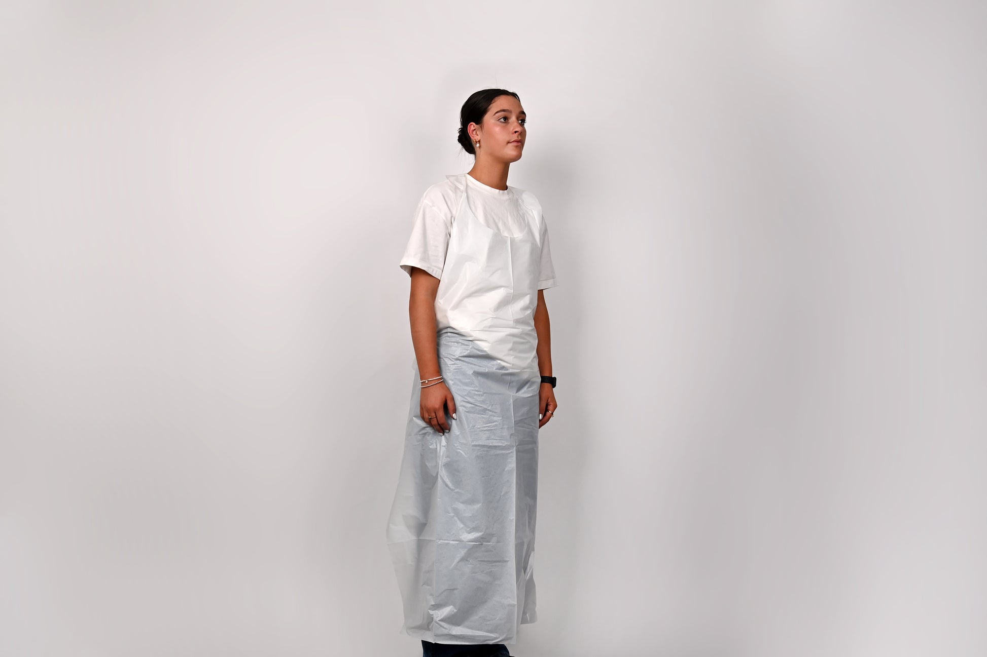 Person wearing a white shirt and light gray apron against a white background