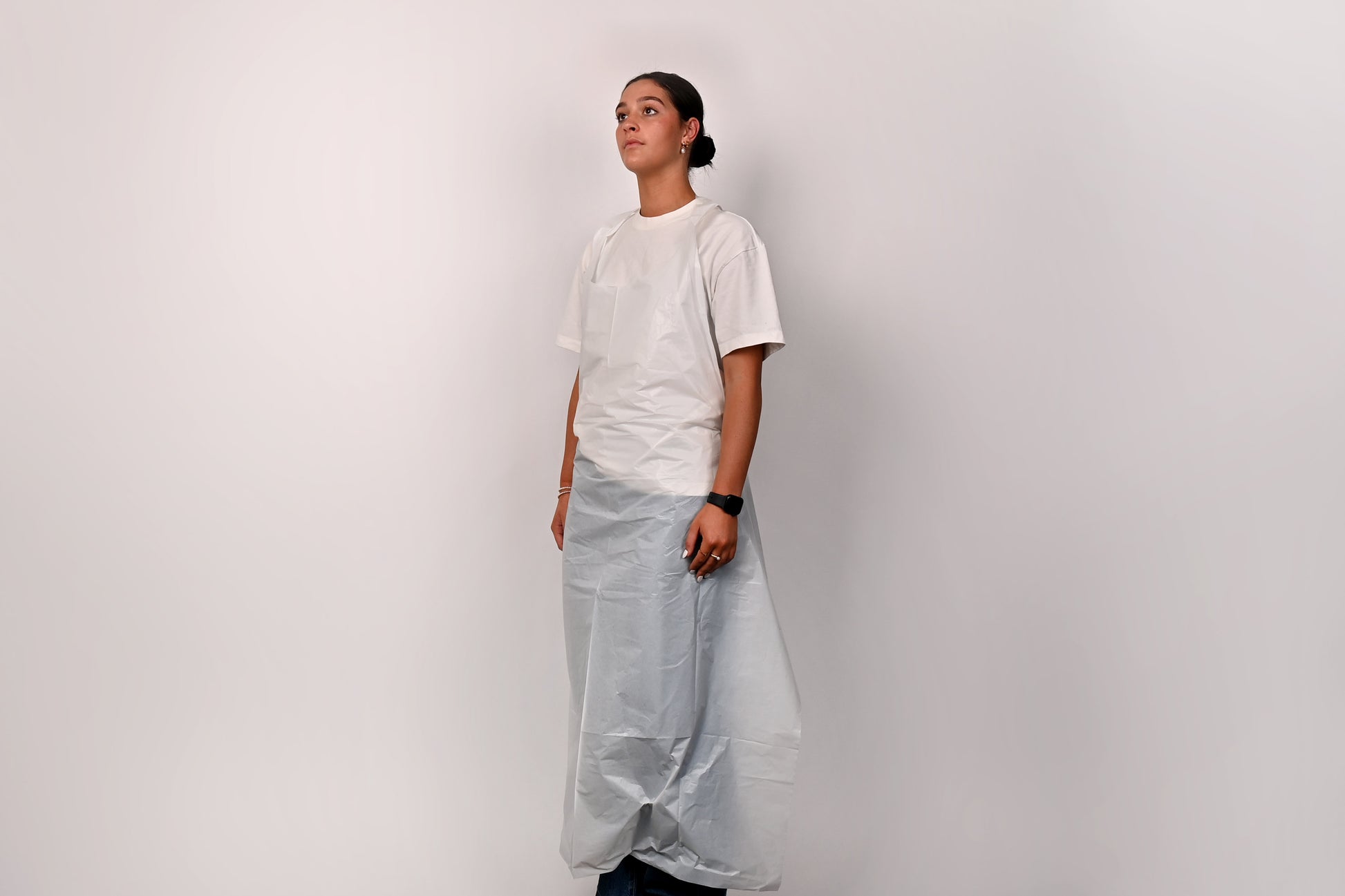 Person wearing a white apron against a plain background