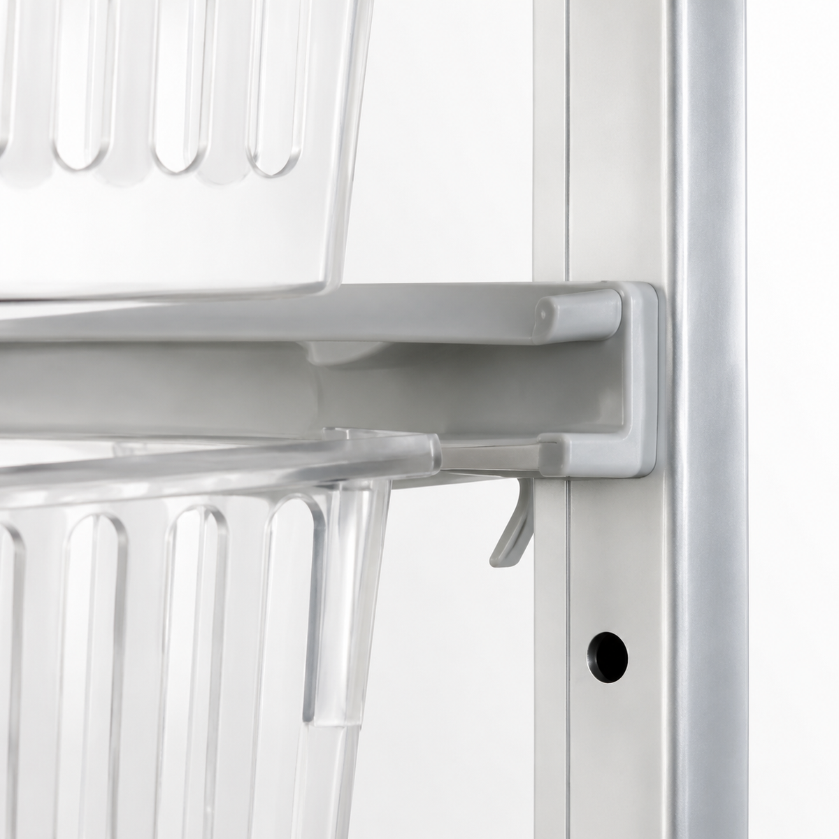 Close-up detail of a silver metal shelving unit with clear plastic baskets attached to a white frame.