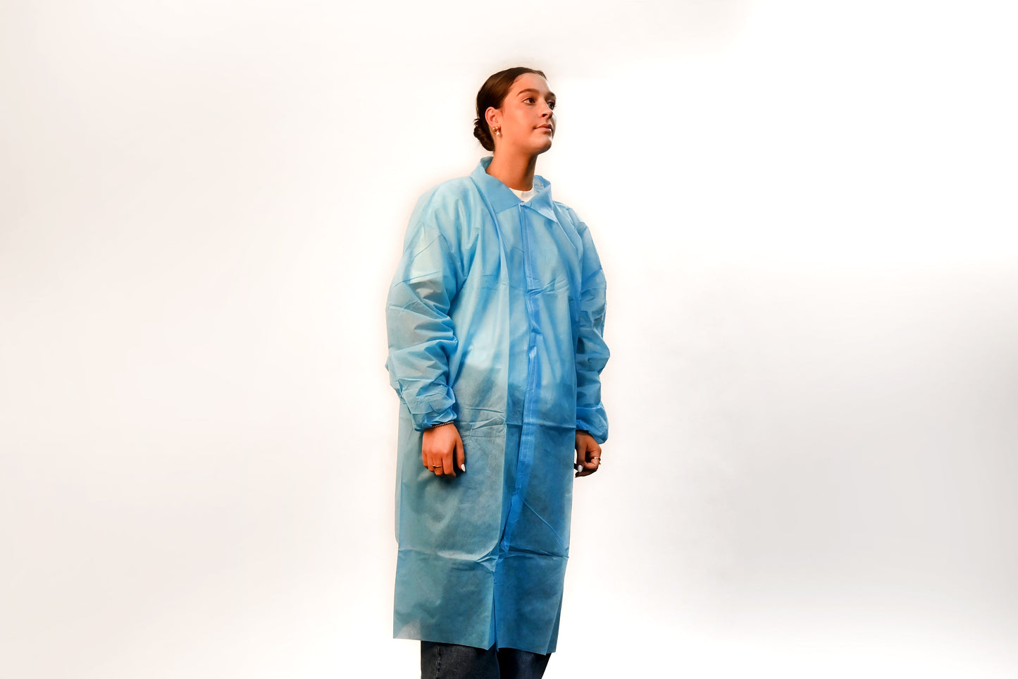 Person wearing a blue disposable lab coat on a white background