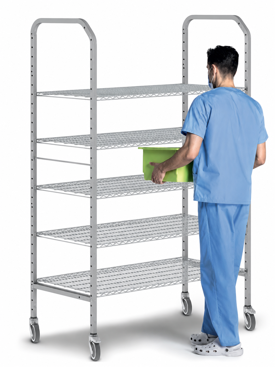 A silver metal medical storage rack with five wire shelves and casters, shown with a person in blue scrubs placing a green container on one of the shelves against a white background.