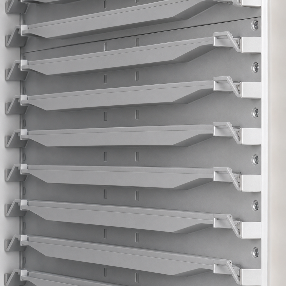 Close-up of a gray plastic shelving or organizer system with multiple horizontal slots and mounting brackets.