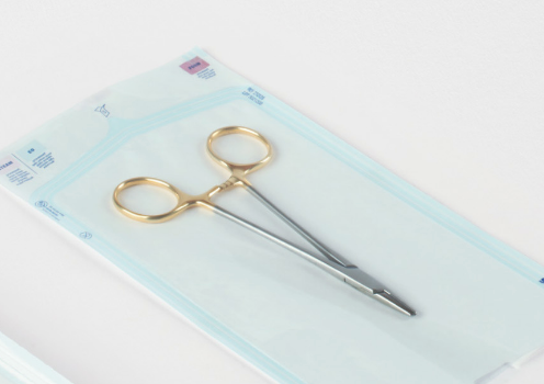 Pair of surgical scissors in a sterilization pouch with a white background