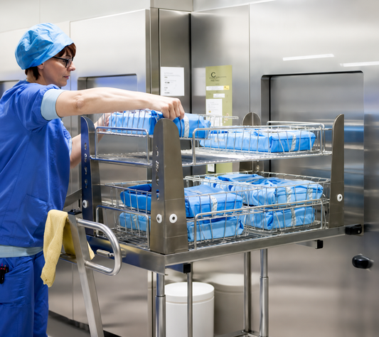 Person in a sterile environment with blue containers on a metal cart