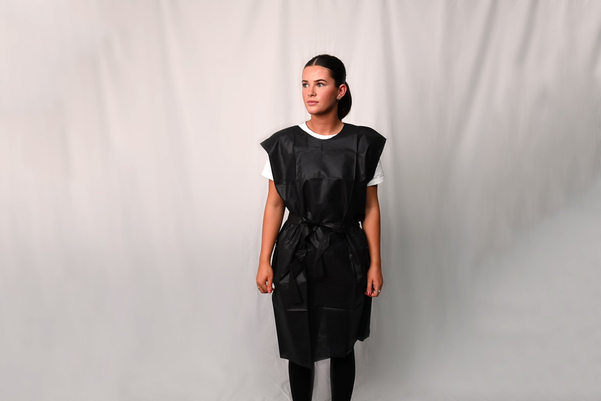 Person wearing a dark X-Ray Gown over a white shirt against a plain background