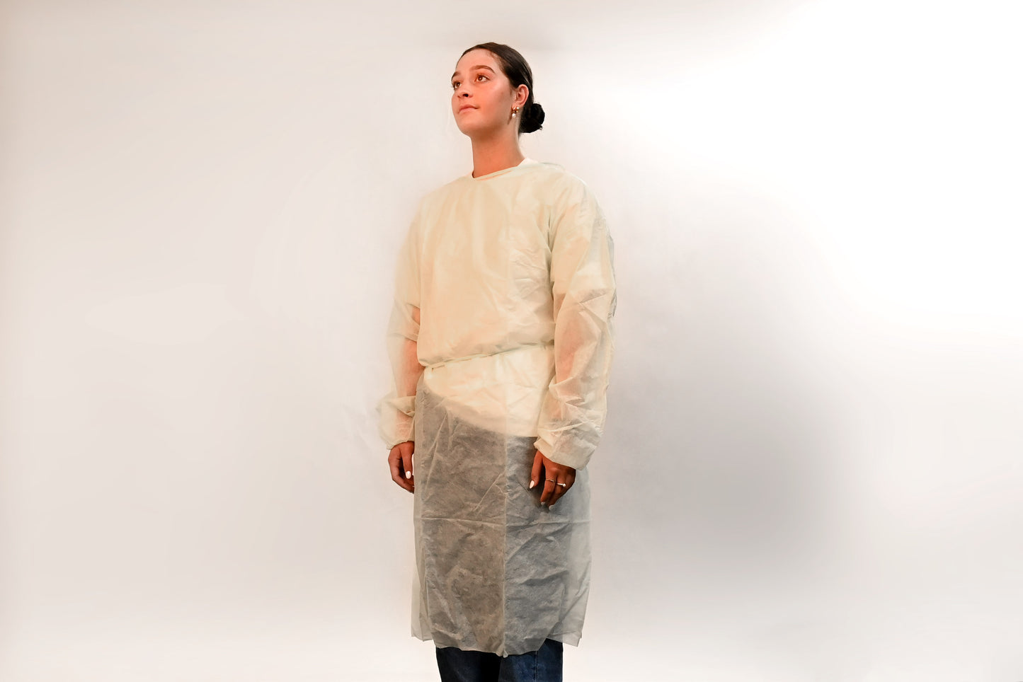 Person wearing a disposable gown on a white background